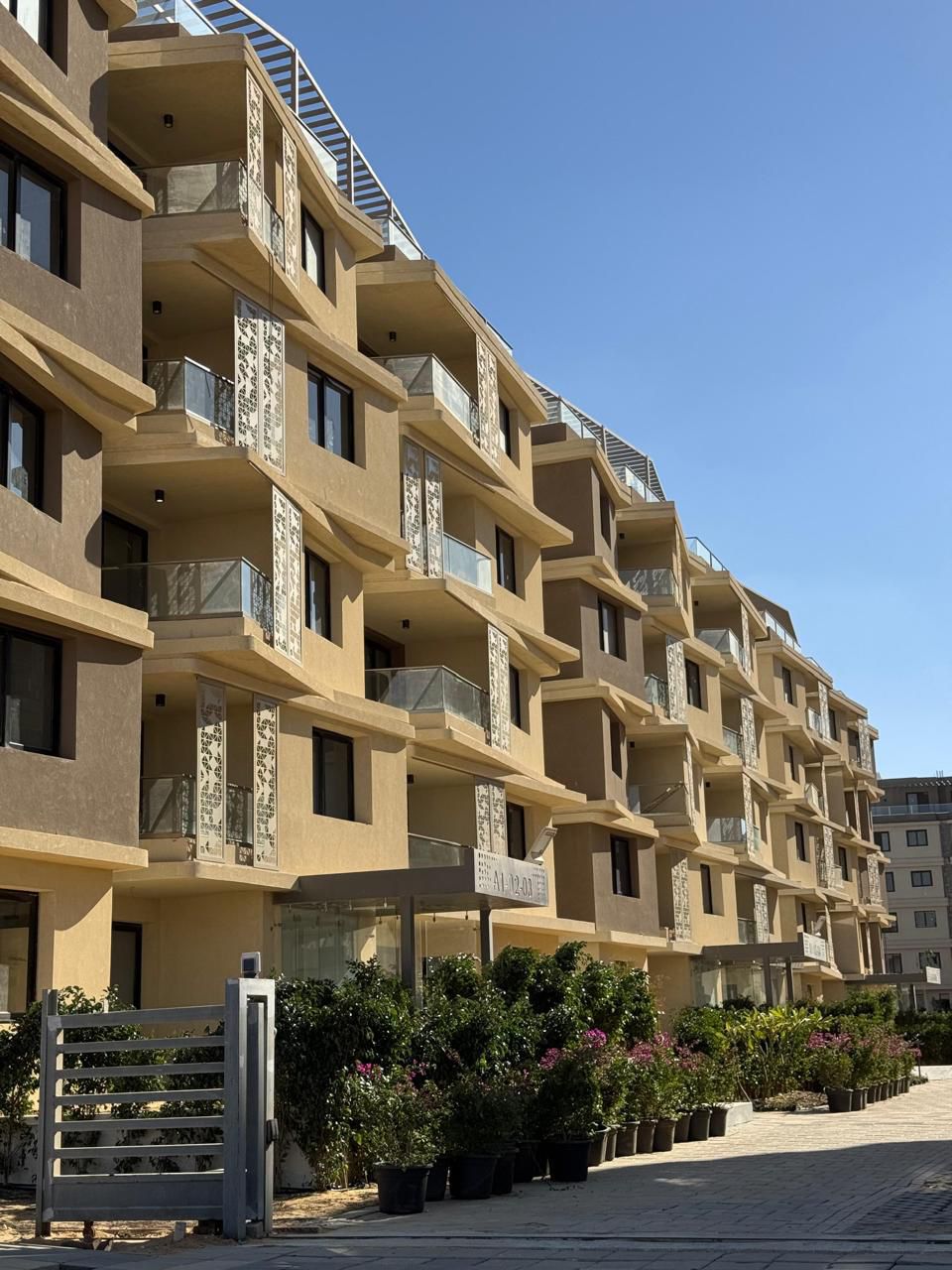 Apartment entrance — Apartment building entrance with a landscaped walkway.