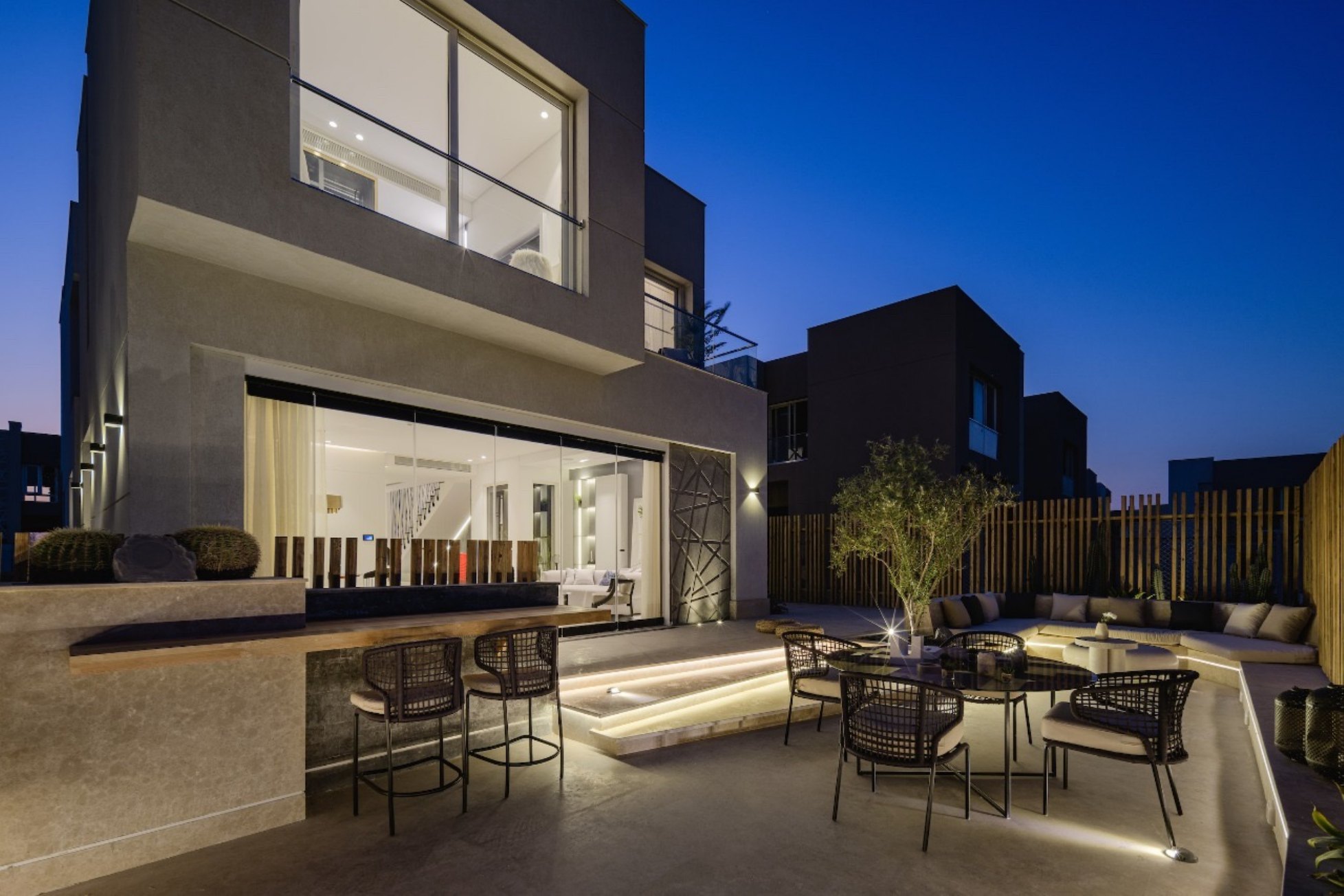 Patio at dusk — A villa patio with dining and lounge seating, lit at dusk.