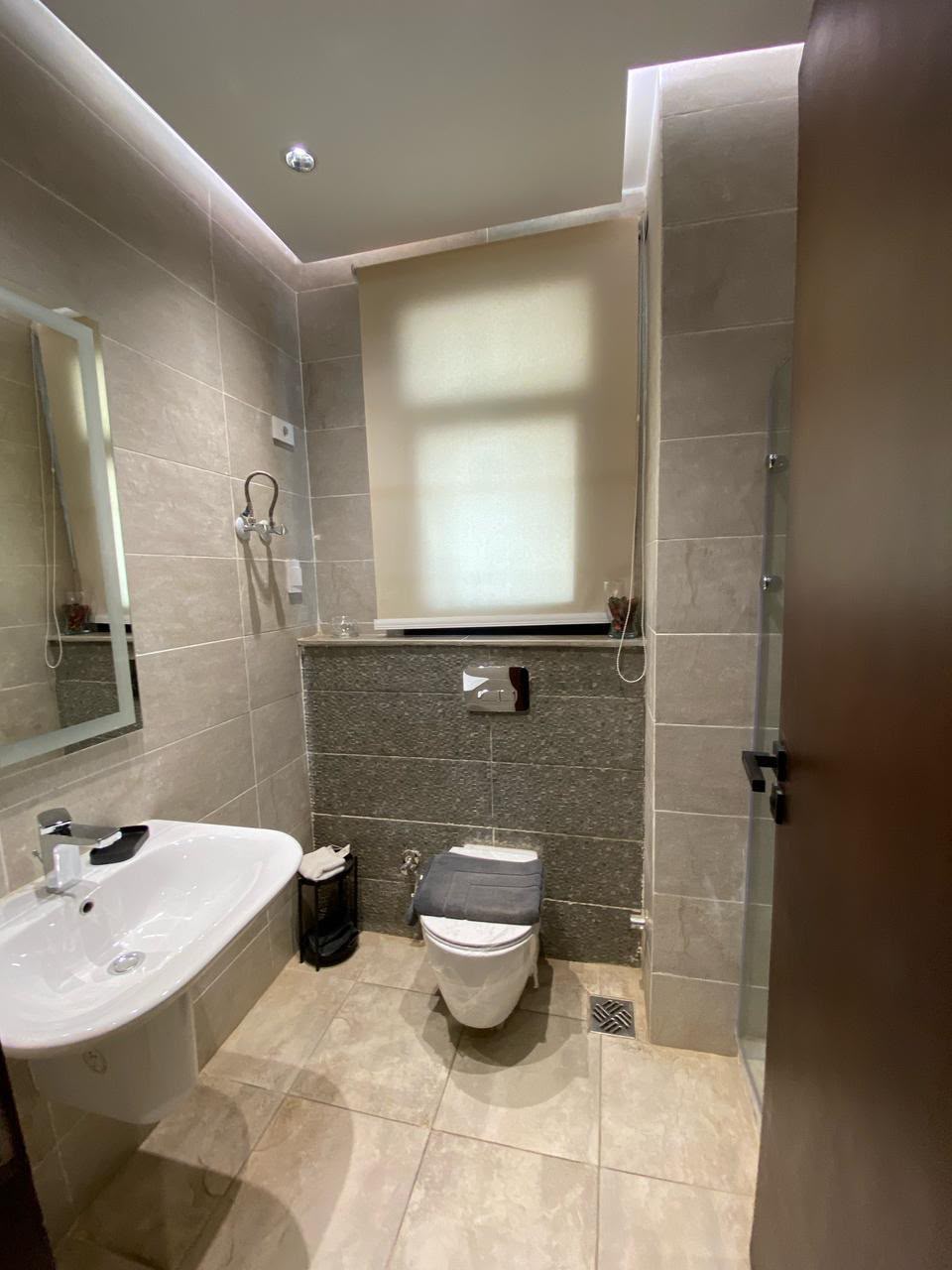 Bathroom — Bathroom with a wall-hung basin and lit mirror.