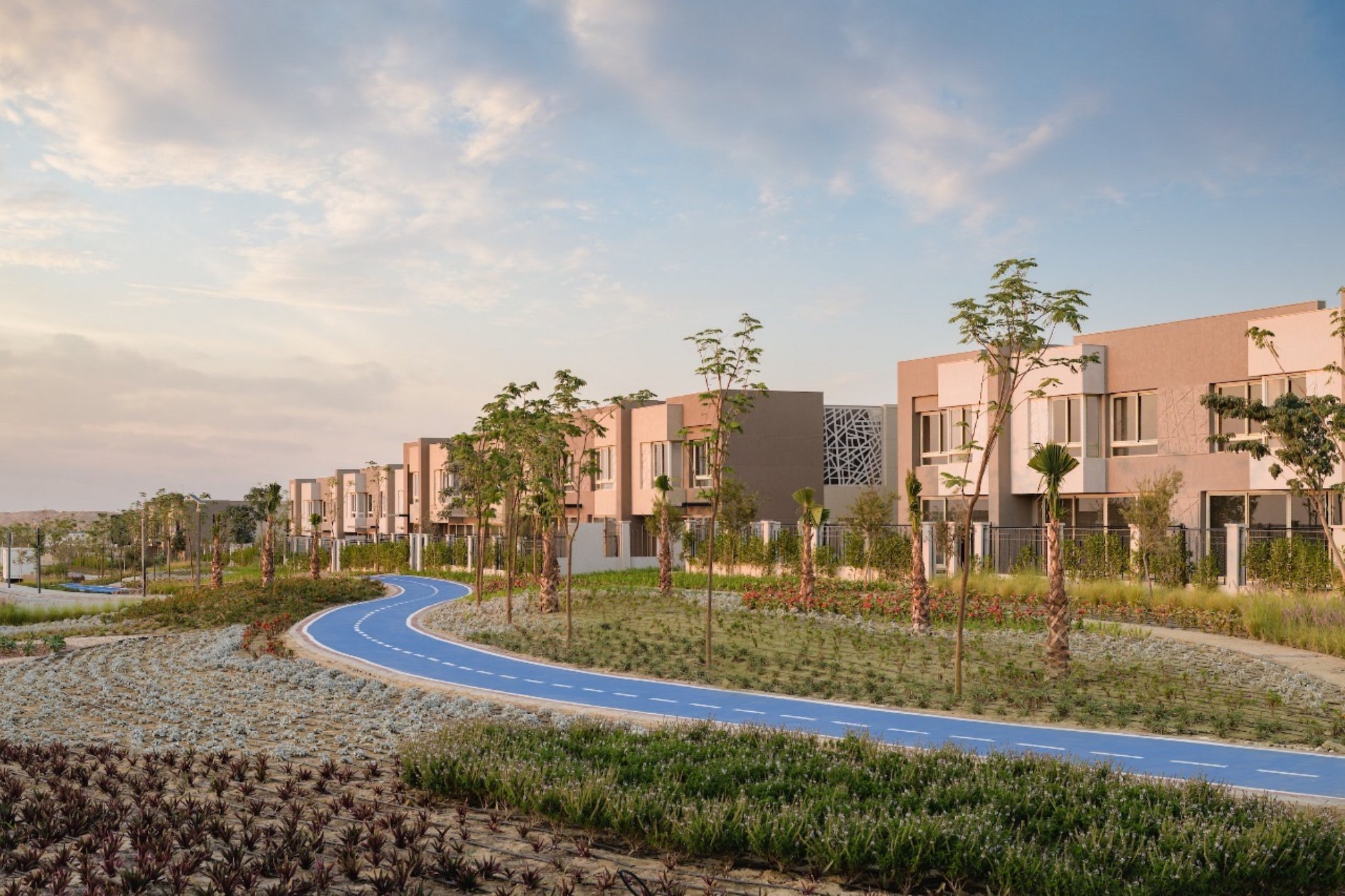 Running track — A blue running and cycling track winding through the community gardens.